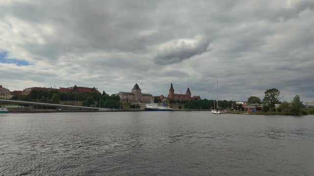 Scenic view of Szczecin's Chrobry Embankment along the Odra River under a cloudy sky, timelapse