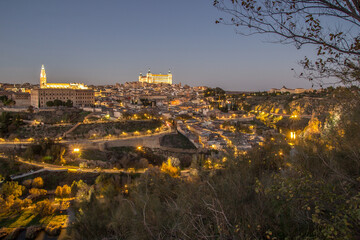 Obraz premium Nigh view of the city of Toledo from the other side of the Tagus river, among the vegetation