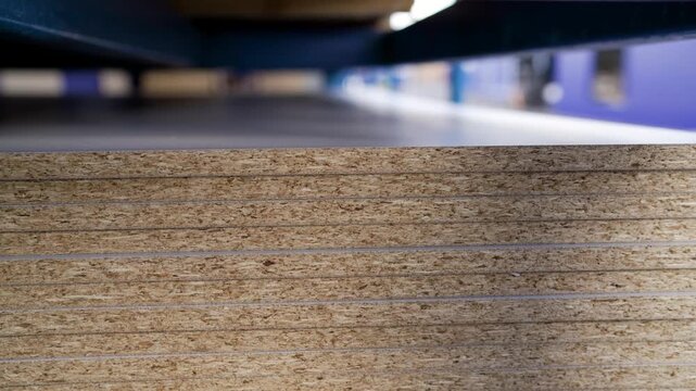 OSB - oriented strand board. Stacked OSB sheets. Sheet material for the construction of frame houses. Blanks for furniture production. Stack of chipboard at a furniture factory.