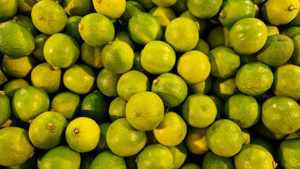 Sale of fruits in the store, limes in plastic boxes. Sale of limes, selective focus. Products in...