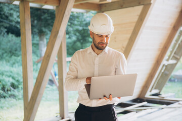 Man builder. Foreman with laptop. Contractor for construction company. Architect in unfinished...