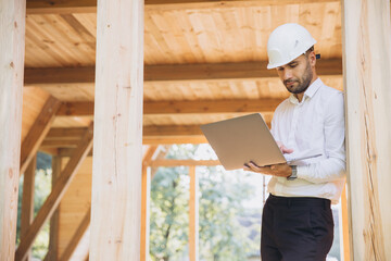 Man builder. Foreman with laptop. Contractor for construction company. Architect in unfinished...