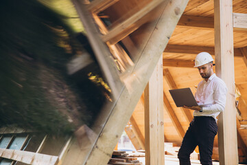 Man builder. Foreman with laptop. Contractor for construction company. Architect in unfinished...