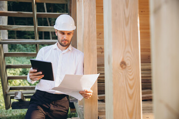 Man builder. Foreman studies blueprints with tablet. Contractor for construction company. Architect...