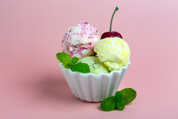  Delicious homemade lemon, cherry and basil ice cream in porcelain cup is served with red cherry and green mint. Copy space.