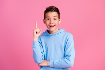 Photo portrait of funny teenager boy eureka point up empty space wear trendy blue outfit isolated on pink color background