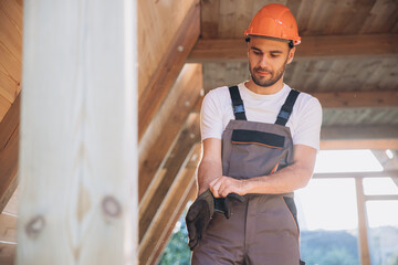 Process of construction new and modern modular house. Worker man in special protective uniform puts...