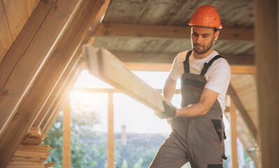 Process of construction new and modern modular house. Worker man in special protective uniform wear...
