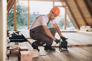 Process of construction new and modern modular house. Worker man in special protective uniform...