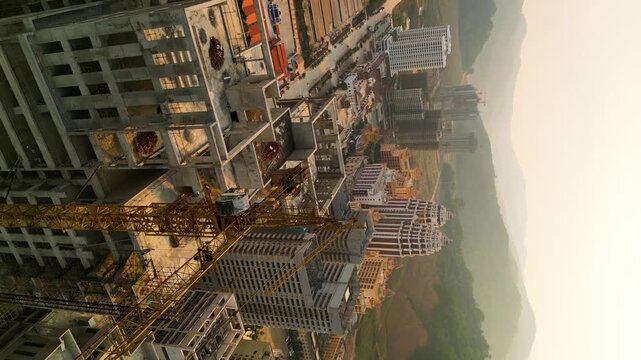 Vertical aerial view of a crane and construction site in the Boten Special Economic Zone, Laos, near the China border. Concept of rapid urban development and economic growth in a cross-border region.