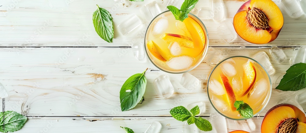 Poster Top down view of a delightful peach lemonade with sparkling water on a white wooden surface with room for text alongside the image. Creative banner. Copyspace image