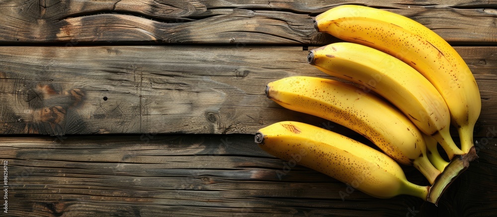 Poster Bananas that are ripe placed on a wooden backdrop with ample copy space image available