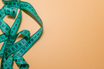 Measuring tape on a blue background. Concept of weight or length. Orange bright background