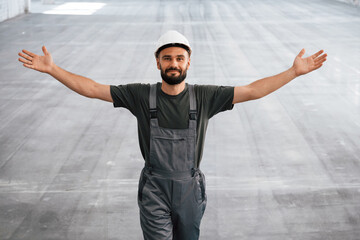 Showing the area by the hands. Male worker is in the empty warehouse