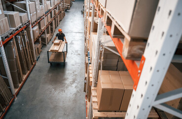 Big area, going with boxes, distant view. Foreman is in the storehouse, shipping distribution business