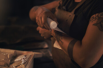 Woman, arm and bandage in workplace for injury, accident and emergency with first aid or medical kit. Worker, wrist and adhesive tape in metal industry for pain, wound and health or safety compliance