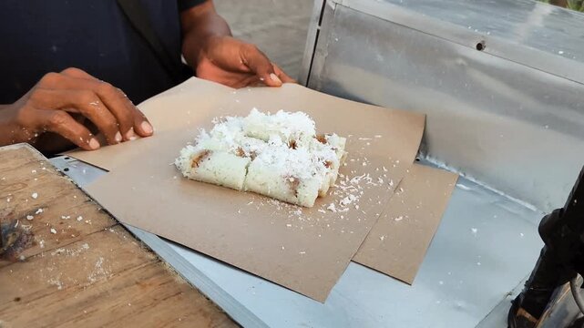 A man serves and wraps Putu cake (Putu bamboo)