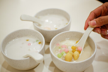 Color Rice Dumpling in Coconut Milk (Bua Loy) in bowl on wooden table.
