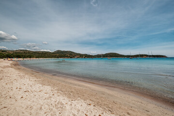 Obraz premium Holidaymakers enjoying the sun, sand and azure Mediterranean sea at Rondinara beach on the south east coast of the island of Corsica
