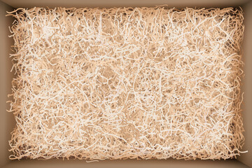 Top view of gift box with beige filler. Cardboard package filled with craft wrapping shredded paper for careful delivery of goods and fragile valuable presents. Vector illustration