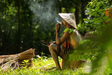 A tattooed elderly man smoking a cigarette in the garden