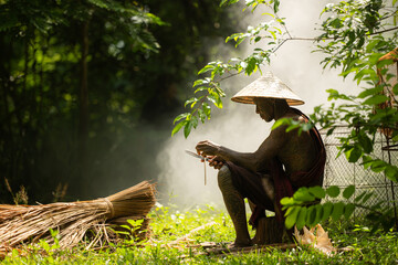 A tattooed elderly man smoking a cigarette in the garden