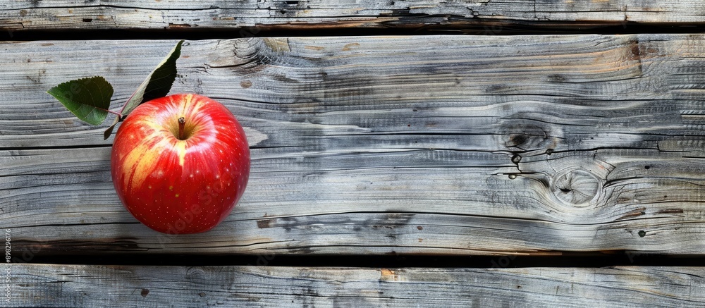 Poster apple placed on weathered wooden surface with copy space image available