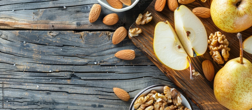 Poster Bright background with sliced pear almonds walnuts on a wooden board depicts a healthy and vegetarian diet concept in a top view copy space image