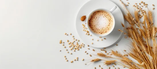Barley coffee cup with grains and spikes arranged on a white table in a flat lay composition providing copy space image