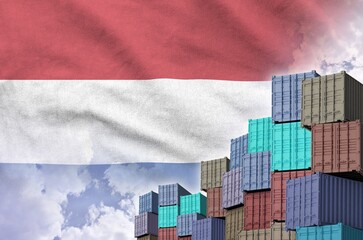 Netherlands flag and big stack of shipping cargo containers in docks with sky background close up