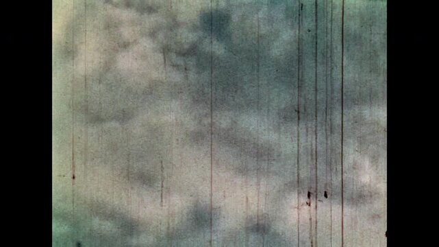 Archive film, green nature on cloudy blue sky in summer. Natural forest on grainy nostalgic cinematic filmstrip. Memories of clean environment. Vintage color film. Climate change archive. Retro 1960s