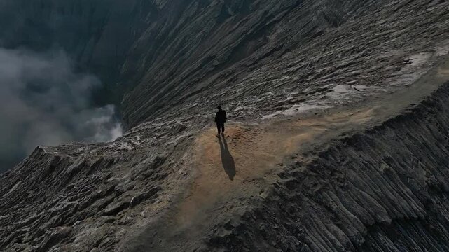 A man at the foot of the Bromo volcano. looks down