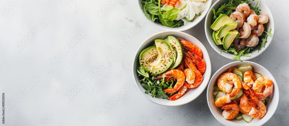 Aufkleber A collection of salads featuring avocado prawns shrimp and greens in bowls on a white backdrop seen from above with space for text or images. Creative banner. Copyspace image