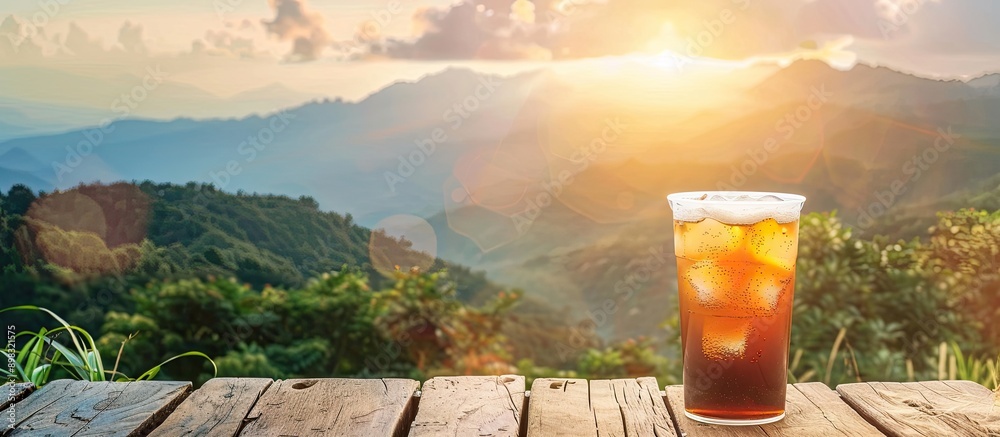 Poster Cold drink on wooden table with mountain backdrop in copy space image