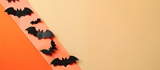 Colorful Halloween bat ornaments arranged on an orange light pink and beige background with empty space for text. Creative banner. Copyspace image