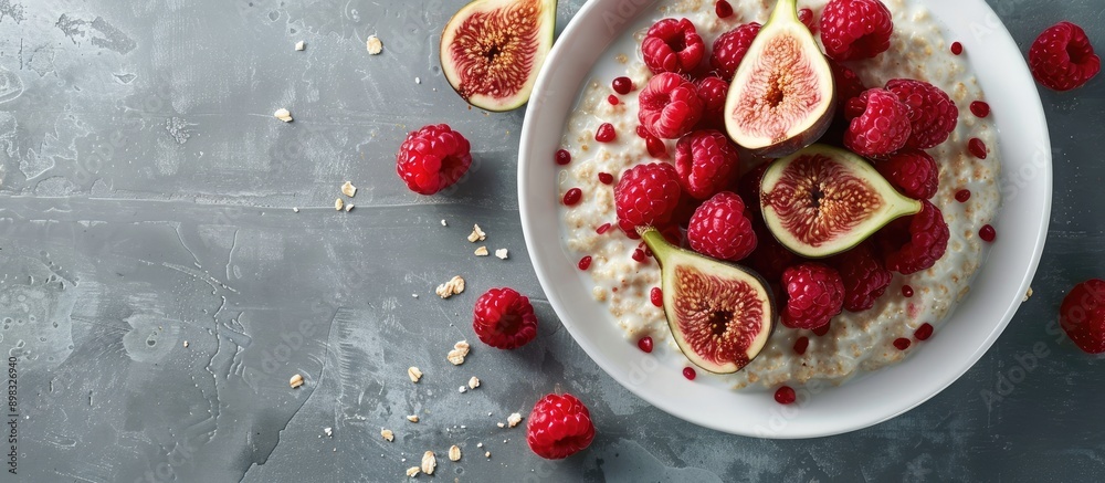 Poster a bowl with oatmeal porridge topped with fresh raspberries and figs set against a plain background f
