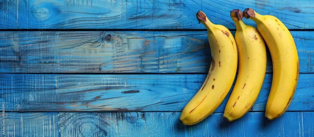 Aufkleber bananas ripe and ready to eat arranged on a blue wooden table with copy space image available