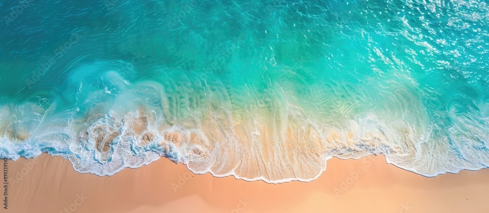Fototapete aerial view of a sandy beach by the ocean with a transparent blue and turquoise water surface offeri