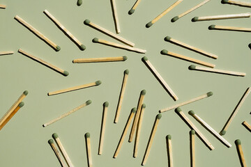 Wooden matchsticks scattered on a green background.