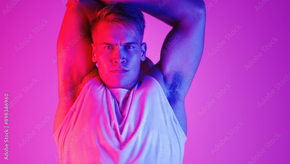 Wall mural Portrait, sport and man stretching arm for health, fitness or wellness isolated on neon background space. Face, serious athlete or warm up muscle to start exercise, workout and flexibility in studio