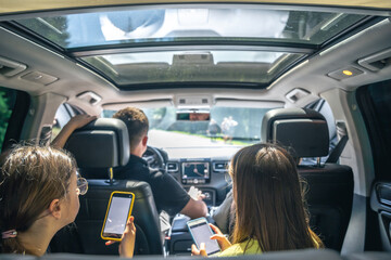 Little girls sitting in back seat of car during family trip.