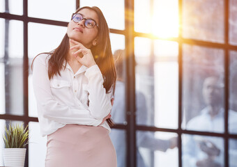 Smiling businesswoman standing at full height and looking at camera in an office