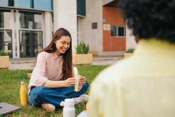 Fototapeta premium Beautiful latin student having lunch with friends, sitting in university campus.