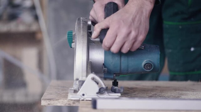 Woodworker using a circular band saw to cut board at the workshop.