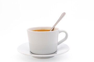 Creamy coffee on a white porcelain cup, isolated on white background with copy space. Side view, close-up.