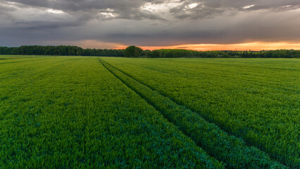Vue aérienne du coucher de soleil sur fond dramatique très nuageux et orageux au milieu des champs et des forêts du bocage normand en France