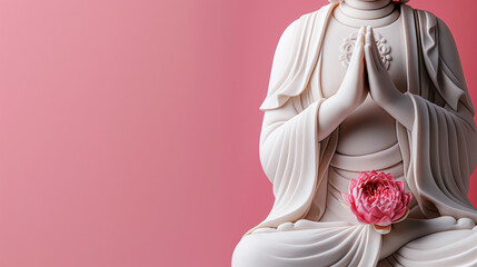 White meditative statue in prayer pose holding a pink lotus flower, set against a pink background.