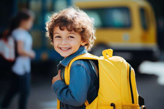 Excited  school boy with backpack with background of school bus. Child with a positive with smiling and happy, back to scholl, Education