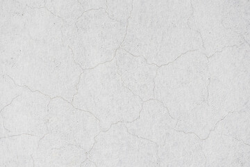 Cracks in walls after plastering and painting. Old cracked concrete wall texture background. White painted plaster with thin cracks in wall.
