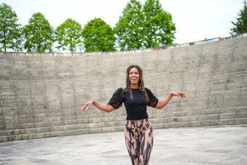 Happy hispanic woman dancing salsa in a public park